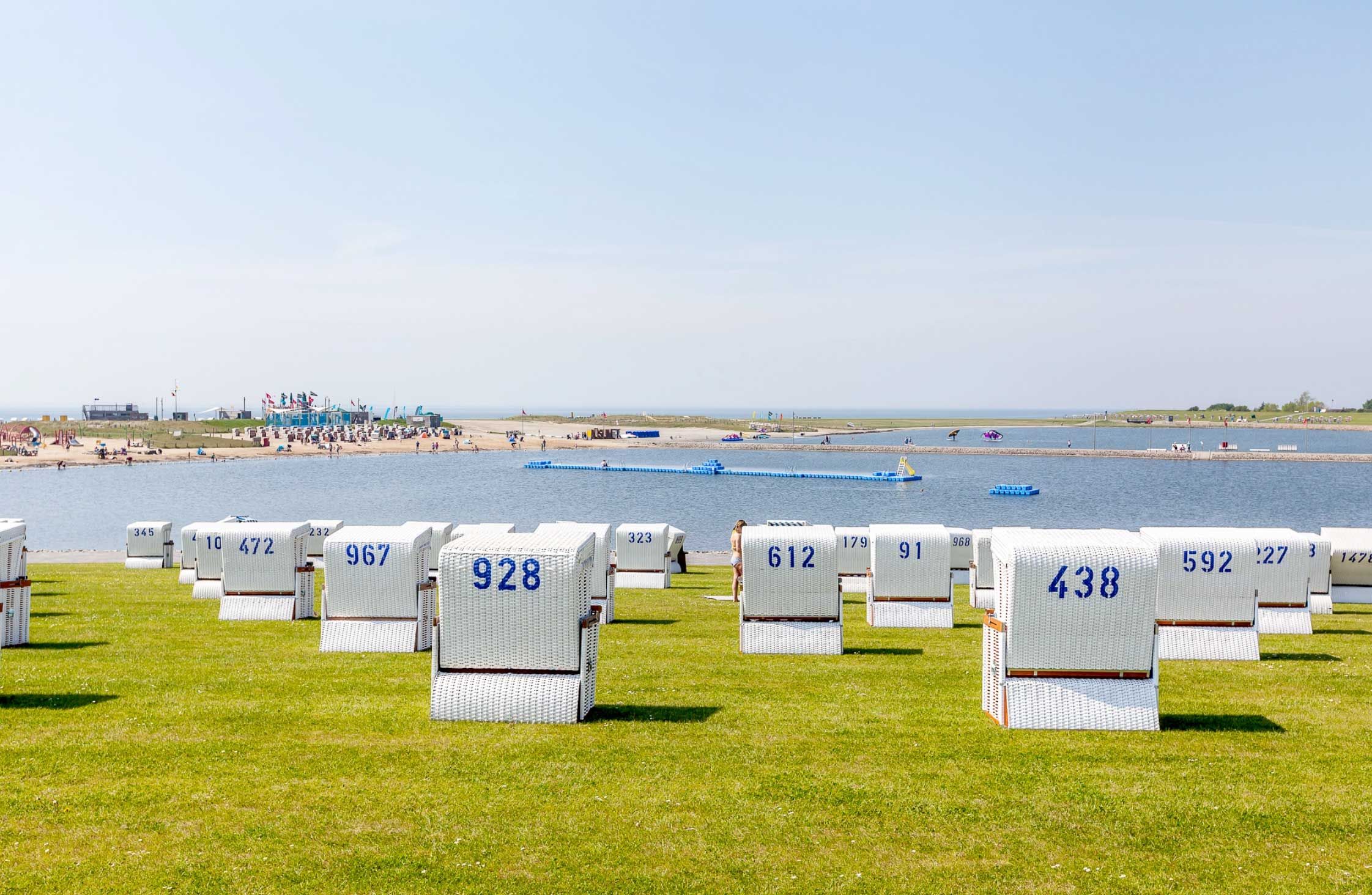 teaser-busuem_familienlagune.jpg Weiße Strandkörbe auf grünem Rasen in der Familenlagune in Büsum