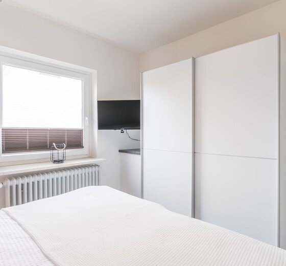 Schlafzimmer mit Kleiderschrank und Fenster-deichlodge lodge.fünf - Ferienhaus / Ferienwohnung Büsum -  16